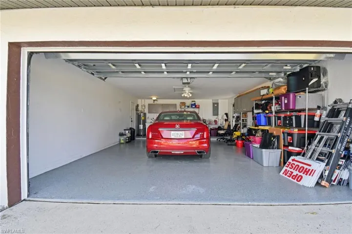 Garage featuring electric panel and electric water heater