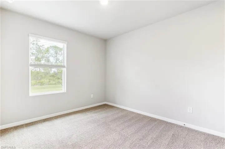 Carpeted empty room with baseboards