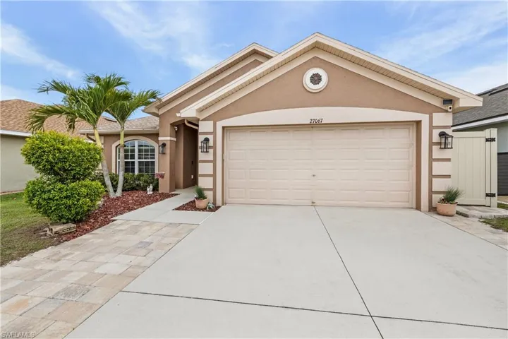 Ranch-style house with a garage, stucco siding, and concrete driveway