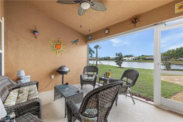 Sunroom with an outdoor lounge area, a patio, a ceiling fan, lofted ceiling, and a water view
