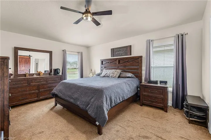 Bedroom with light carpet and a ceiling fan