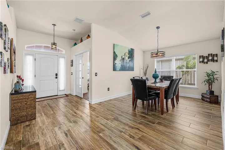 Dining room with wood tiled floors and lofted ceiling