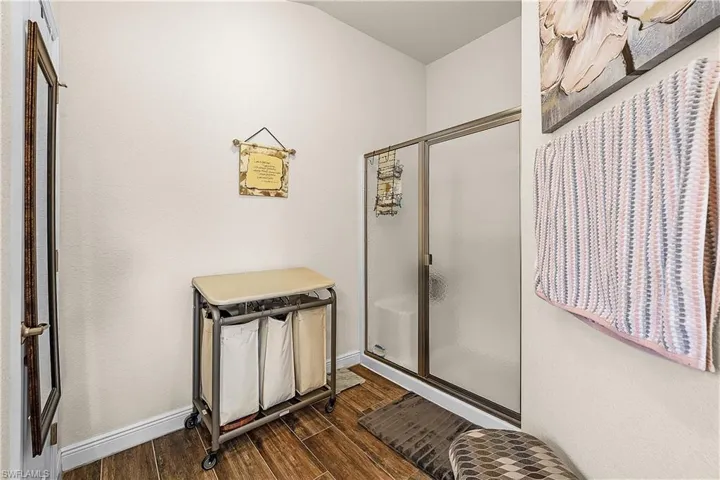 Full bath with a shower stall and wood tiled floors