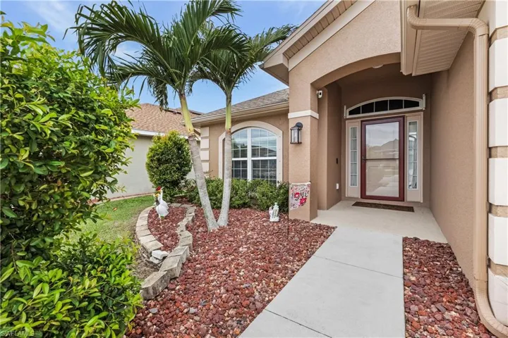 Doorway to property with stucco siding and a shingled roof