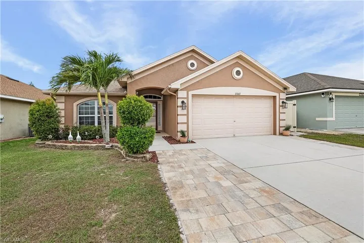 Ranch-style house featuring stucco siding, a garage, concrete driveway, and a front yard