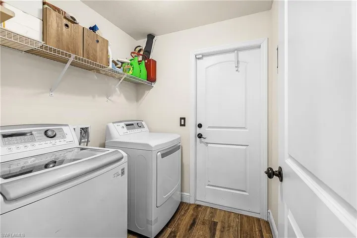 Laundry room with dark wood-type flooring and separate washer and dryer