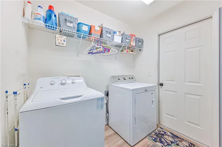 Laundry room featuring washer and dryer and light wood-style floors