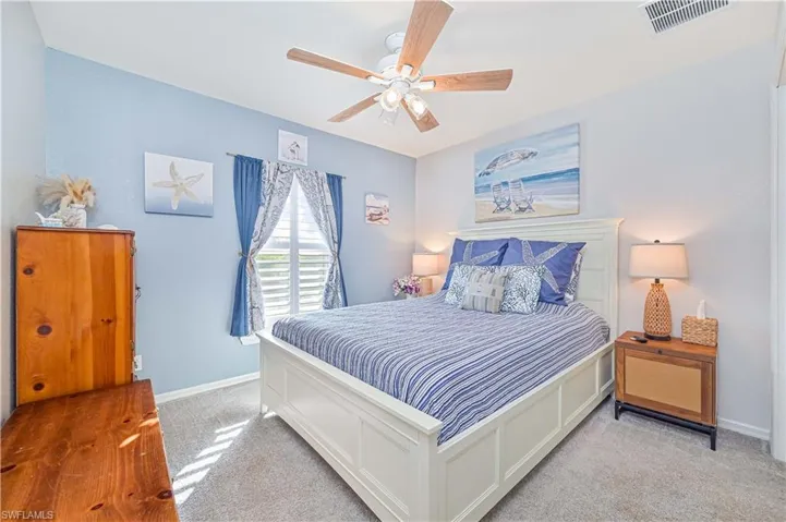 Carpeted bedroom with ceiling fan and baseboards
