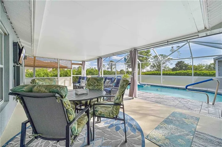 Outdoor pool featuring a lanai, a sunroom, and a patio