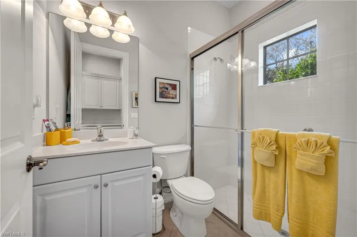 Bathroom with vanity, a shower stall, and toilet