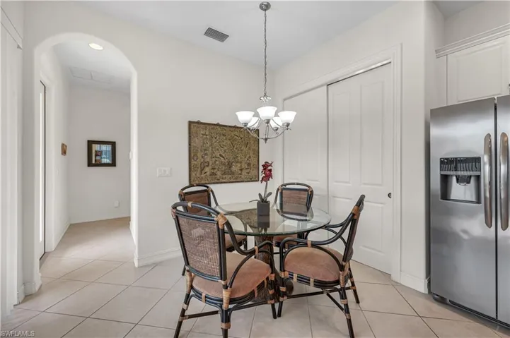 Dining space featuring light tile patterned floors, a chandelier, visible vents, and baseboards