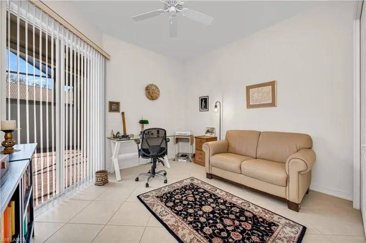 Office space with ceiling fan, baseboards, and light tile patterned floors