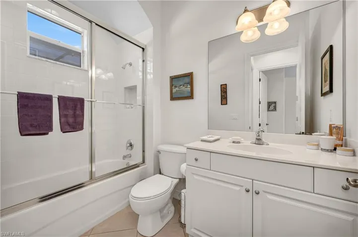 Full bathroom with toilet, shower / bath combination with glass door, vanity, and tile patterned floors
