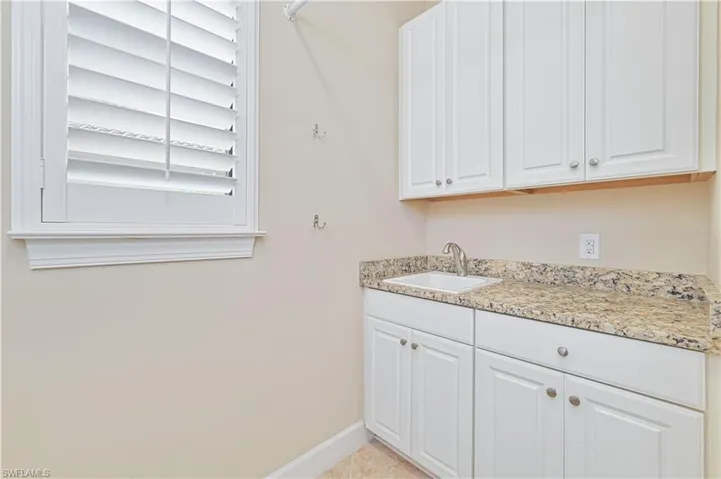 Washroom featuring baseboards and a sink