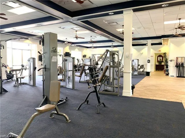 Gym with a drop ceiling and a ceiling fan