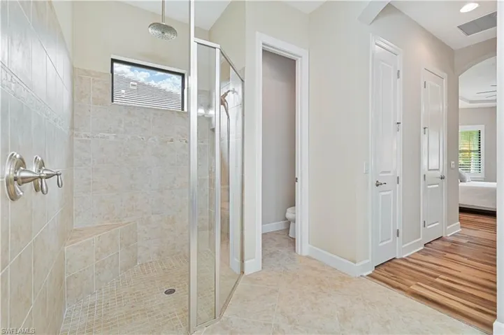 Ensuite bathroom with a stall shower and light tile patterned floors