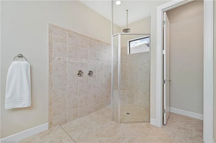 Bathroom with a walk in shower and tile patterned flooring