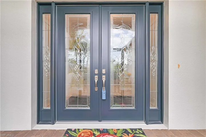 Property entrance with french doors and stucco siding