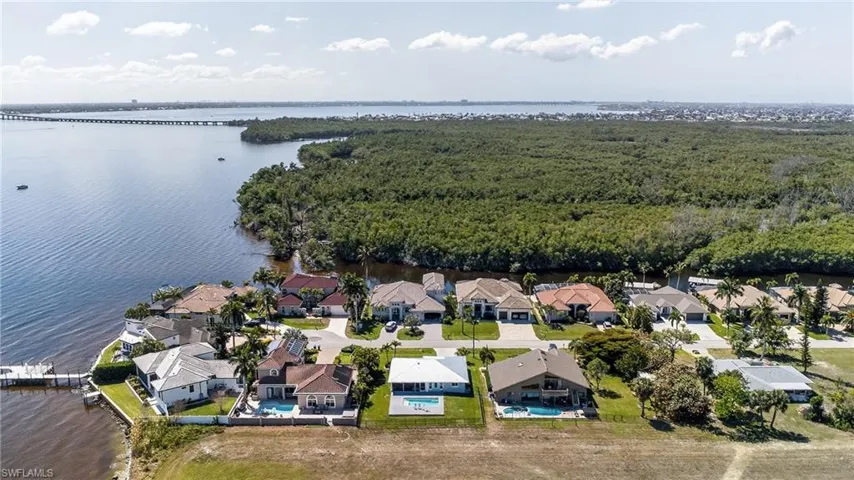 Aerial perspective of suburban area featuring a nearby body of water