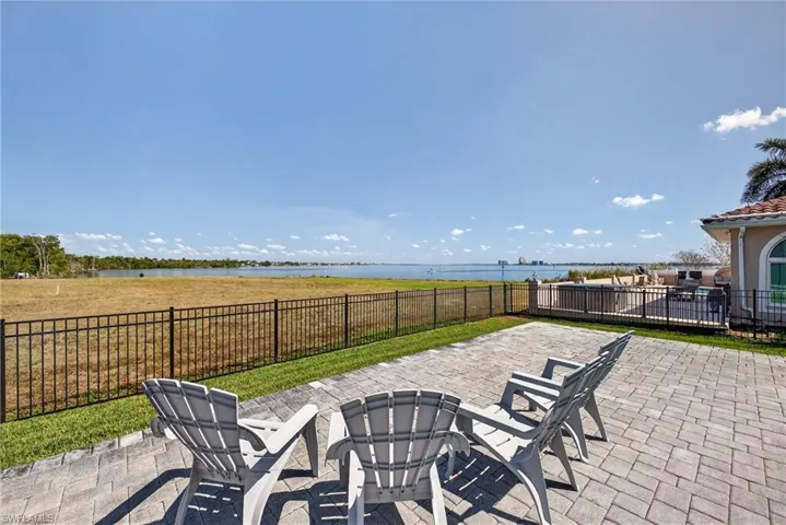 Fenced backyard with a patio and a water view