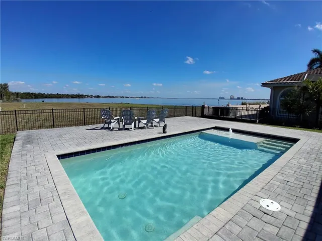 View of pool with a water view and patio surround