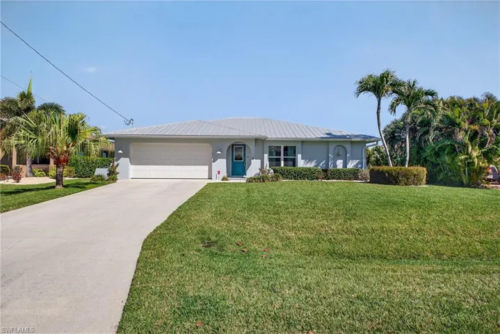 Ranch-style house featuring a garage, a front yard, and concrete driveway