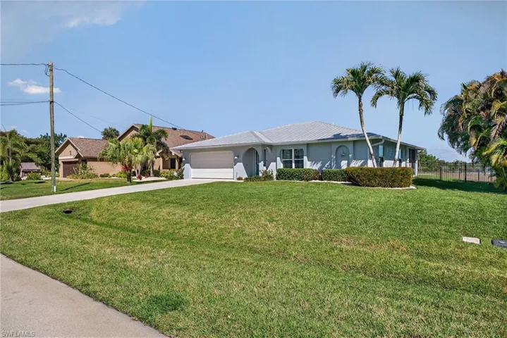 Ranch-style home featuring concrete driveway, an attached garage, and stucco siding