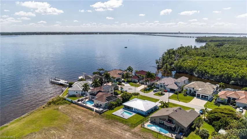 Aerial perspective of suburban area featuring a nearby body of water and a notable bridge