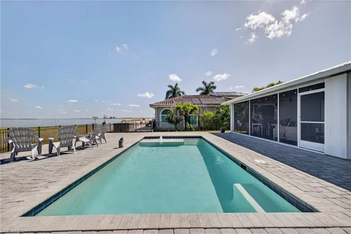 View of swimming pool featuring patio surround and a sunroom