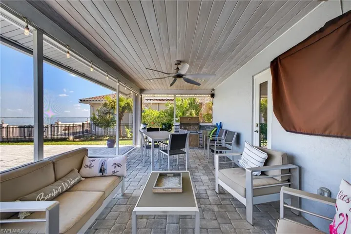 View of patio / terrace featuring a ceiling fan, area for grilling, a water view, and outdoor lounge area