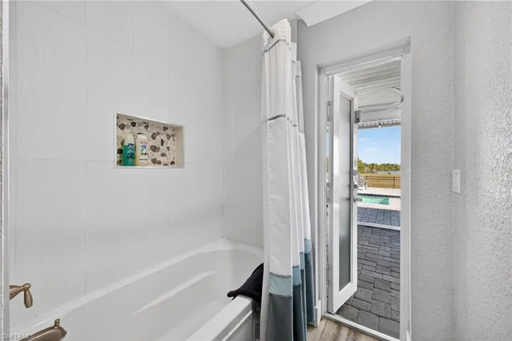 Full bathroom with shower / bath combo and light wood-type flooring