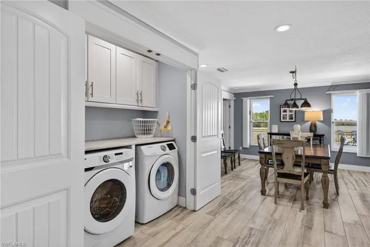 Laundry area featuring recessed lighting, washing machine and dryer, light wood-type flooring, cabinet space, and a textured ceiling