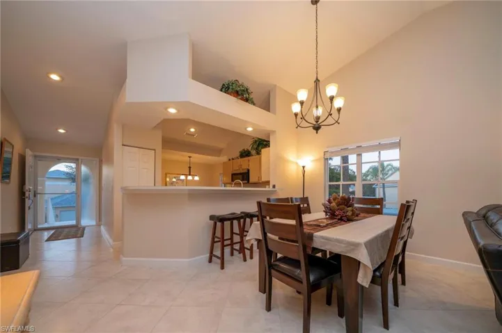 Dining room with a chandelier, healthy amount of natural light, high vaulted ceiling