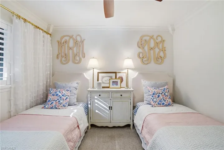 Bedroom with ornamental molding, a ceiling fan, and light colored carpet