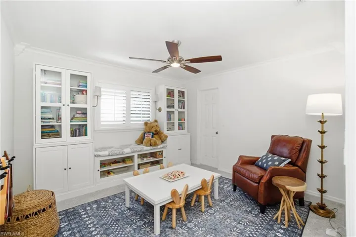 Living area with crown molding, carpet, and ceiling fan