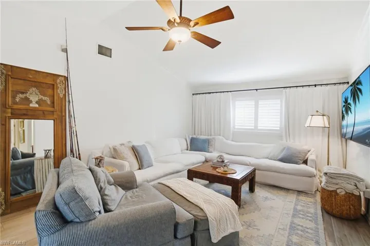 Living area with wood finished floors, lofted ceiling, and ceiling fan