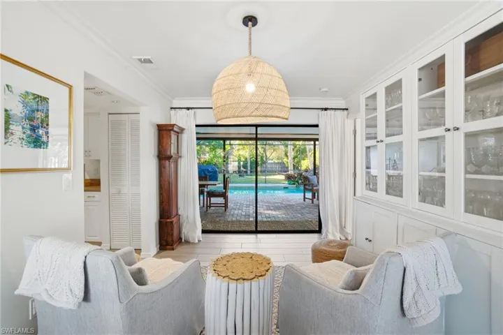 Living area with crown molding and a sunroom