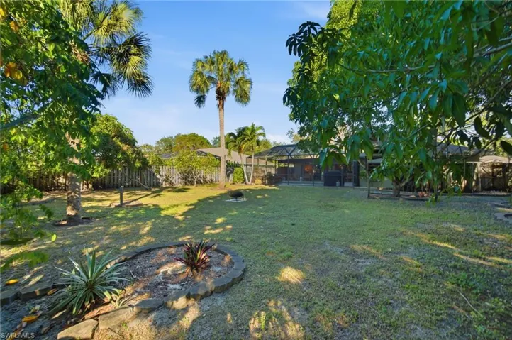 Fenced backyard featuring a lanai