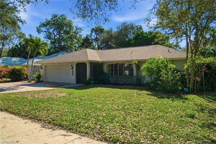 Ranch-style home with a front lawn, driveway, an attached garage, stucco siding, and a shingled roof