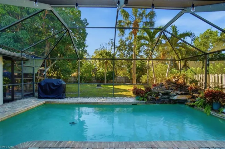 View of swimming pool with a sunroom, a grill, a fenced backyard, glass enclosure, and a patio area