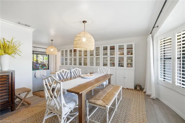 Dining area featuring ornamental molding and light wood-style flooring