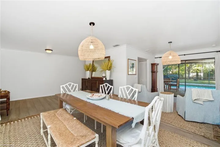 Dining space with light wood-style flooring and ornamental molding