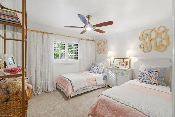 Bedroom featuring carpet, ornamental molding, and ceiling fan