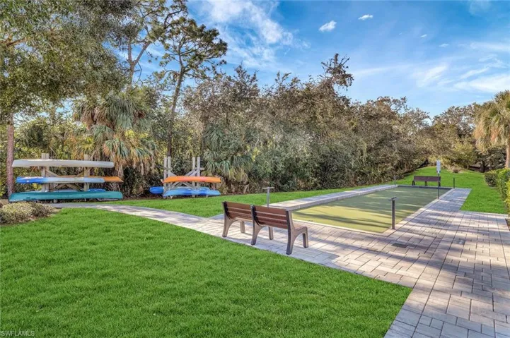 View of home's community with a lawn, a game area, and view of scattered trees