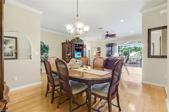 Dining room featuring ornamental molding, light wood finished floors, ceiling fan, a chandelier, and recessed lighting