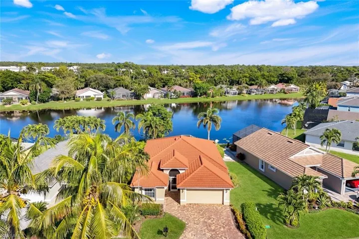Aerial perspective of suburban area with a large body of water and a tree filled landscape
