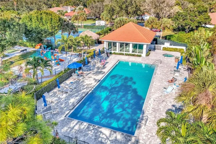 Community pool featuring a patio, a sunroom, and view of wooded area