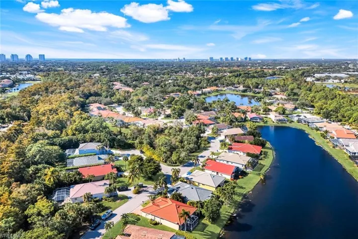 Aerial view of residential area featuring city skyline and a nearby body of water