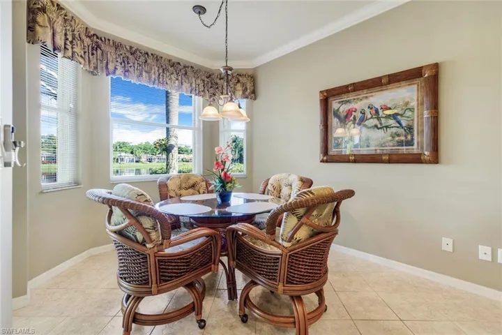 Dining room with crown molding and light tile patterned flooring