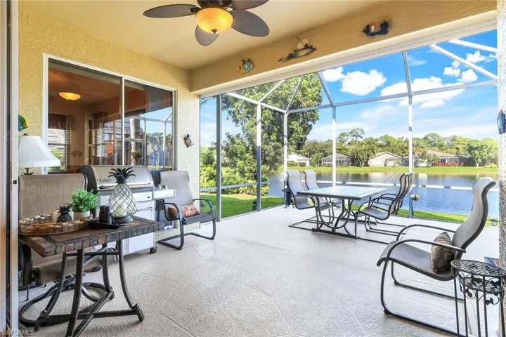 Sunroom featuring a patio, ceiling fan, a water view, and healthy amount of natural light